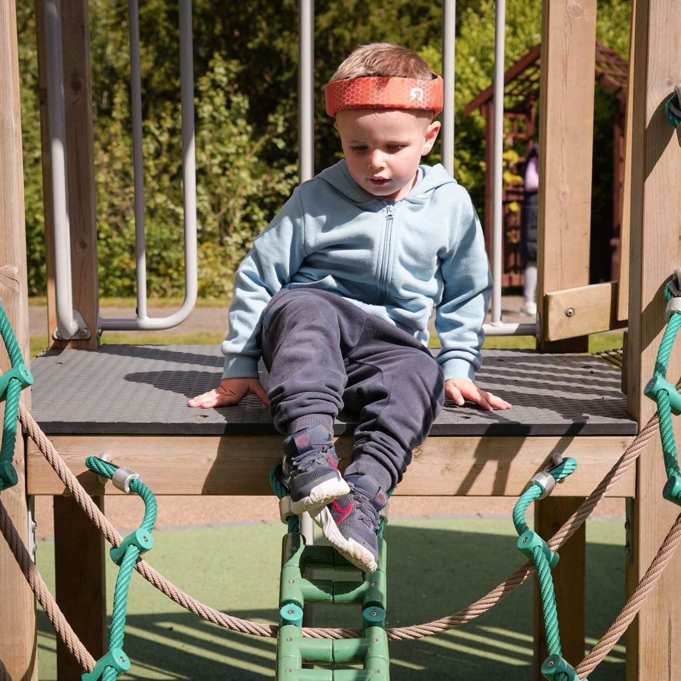 Young boy wearing Rezon Halos® brain protection at the park. Image shows a young boy in the park. He is wearing Rezon Halos® brain protection.