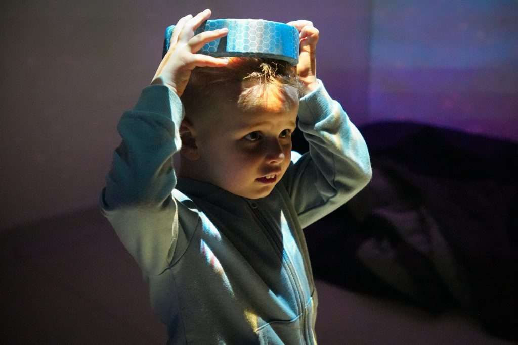 A young boy with autism putting his Rezon Halos® brain protection on.